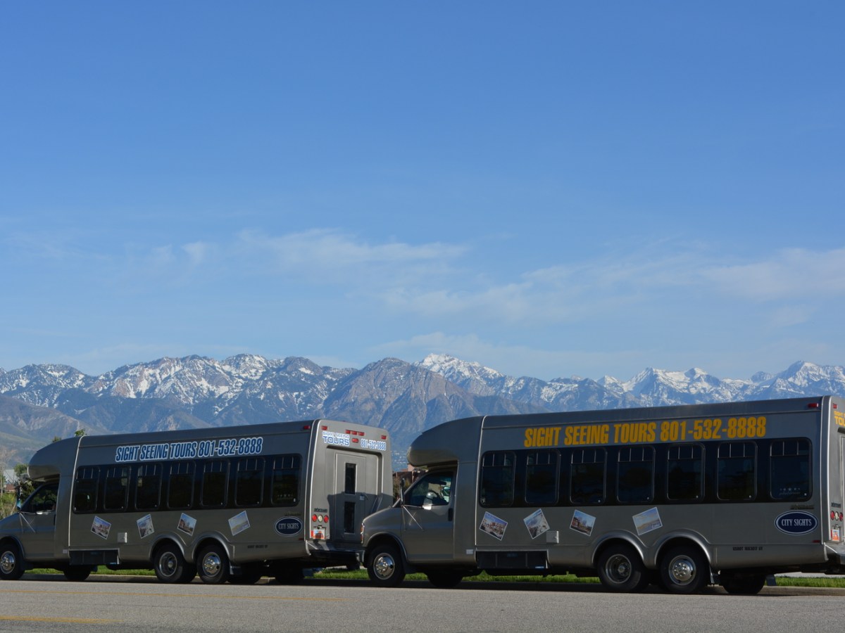 Two shuttle buses with mountains in background